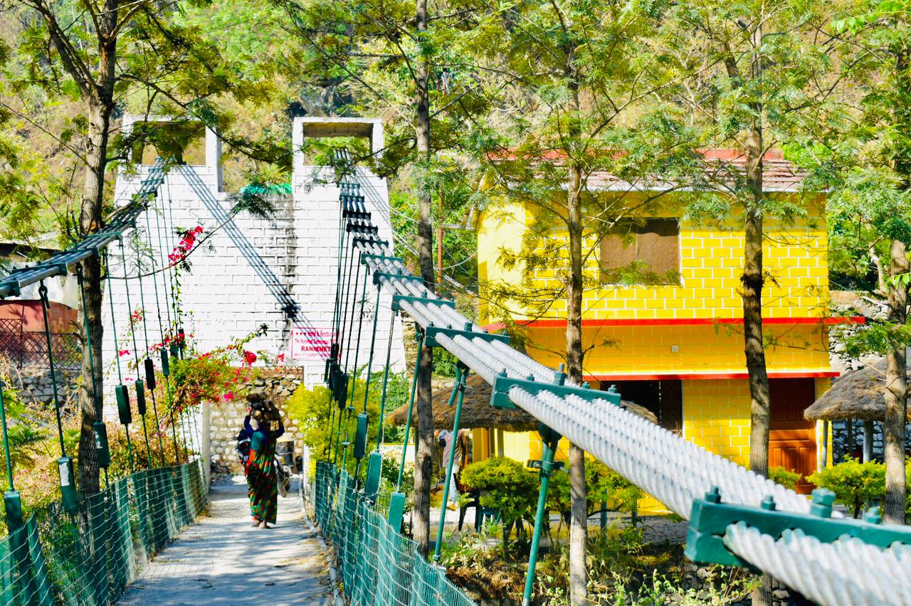Scenic camp area with rope bridge and lush greenery near Kainchi Dham