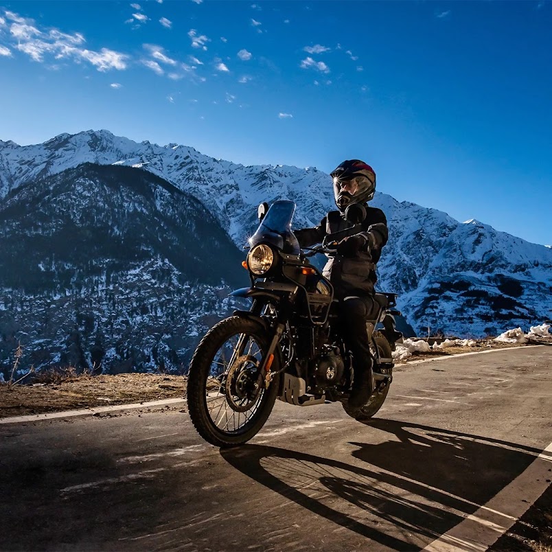 Rider on Royal Enfield with snow peaks in background