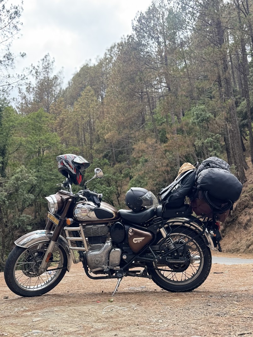 Scooty parked on a scenic hill road in Nainital